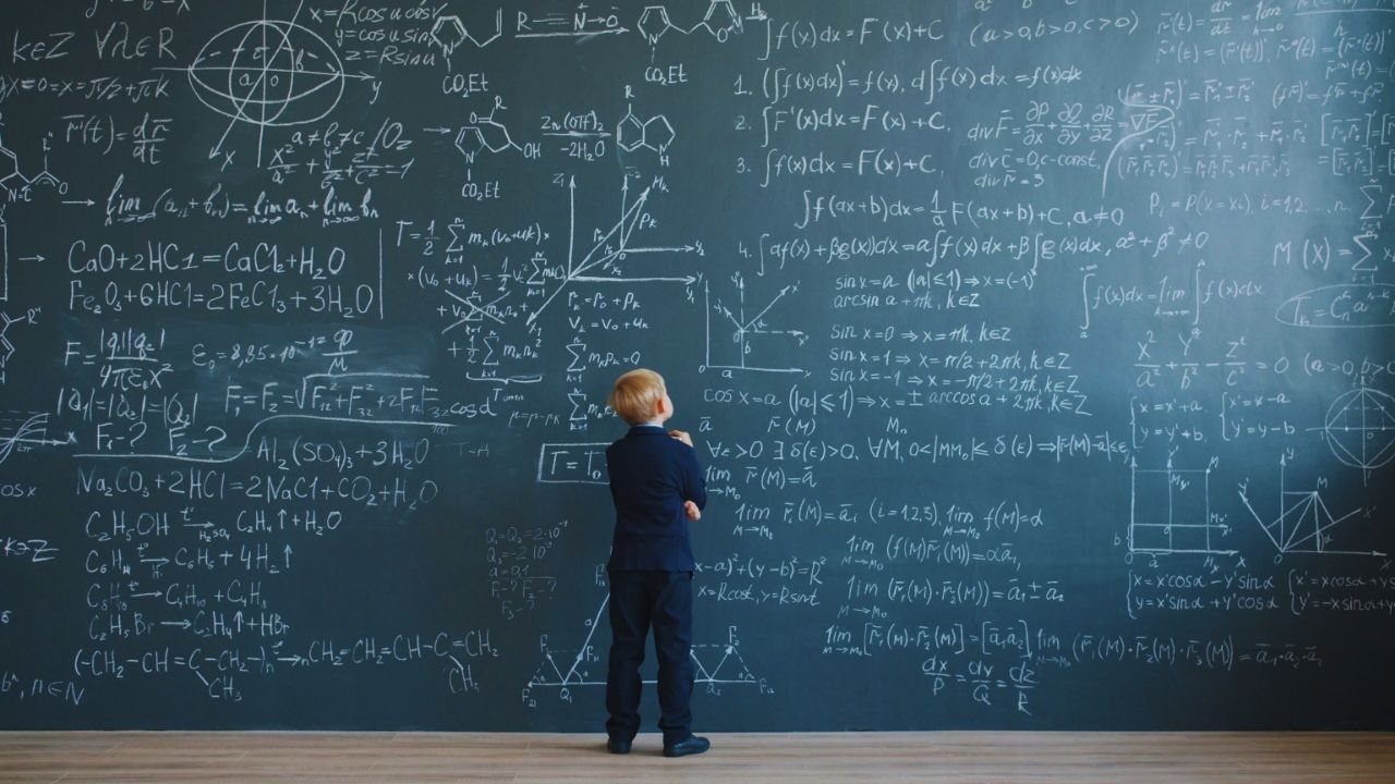 Kind vor beschriebener Tafel in Bildungseinrichtung – Gebäudereinigung für Schulen, Kitas und Lernräume