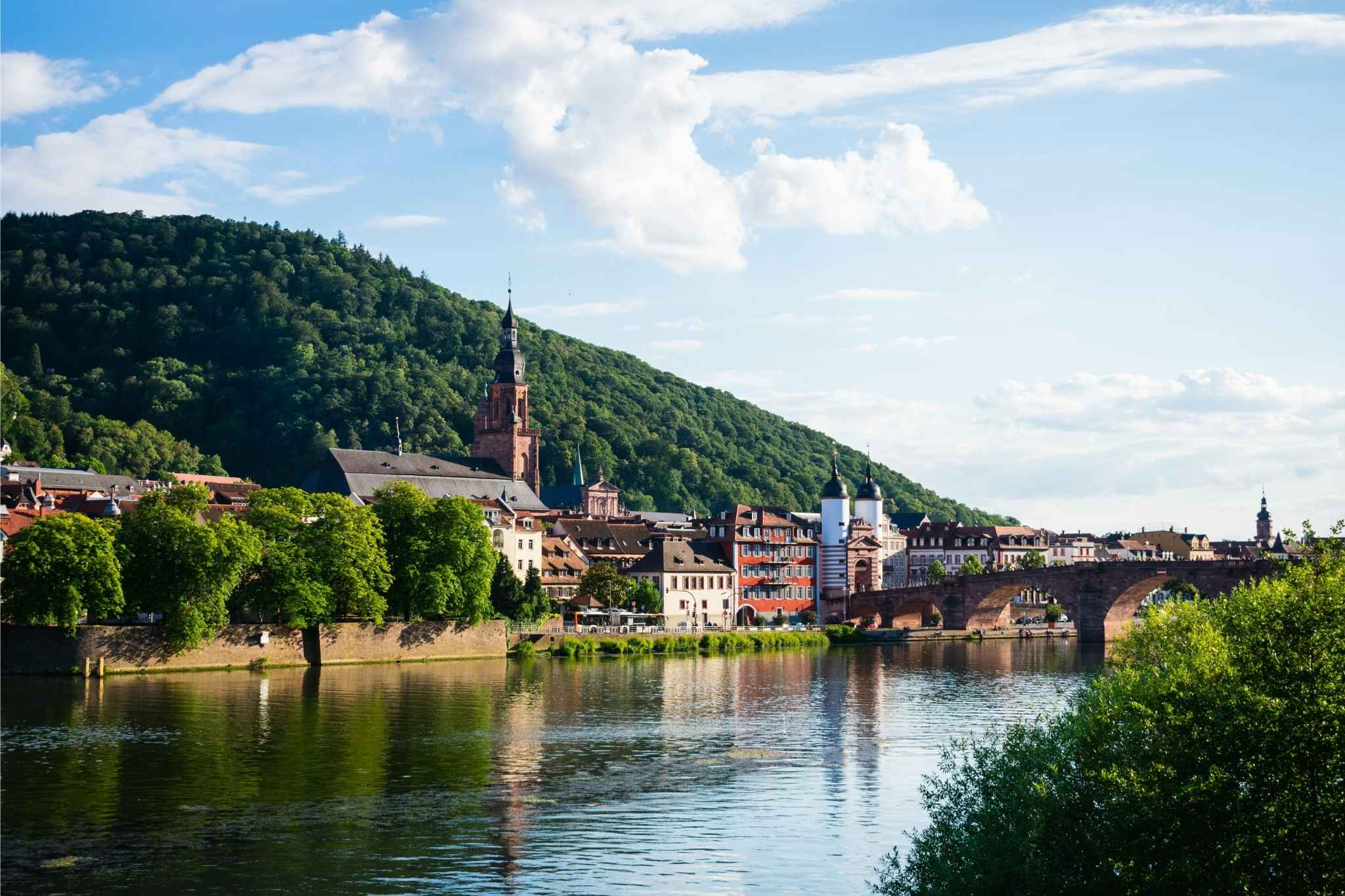 Historische Alte Brücke über den Neckar mit Blick auf die Heidelberger Altstadt – malerisches Stadtpanorama mit Fluss, Brücke und klassischer Architektur.