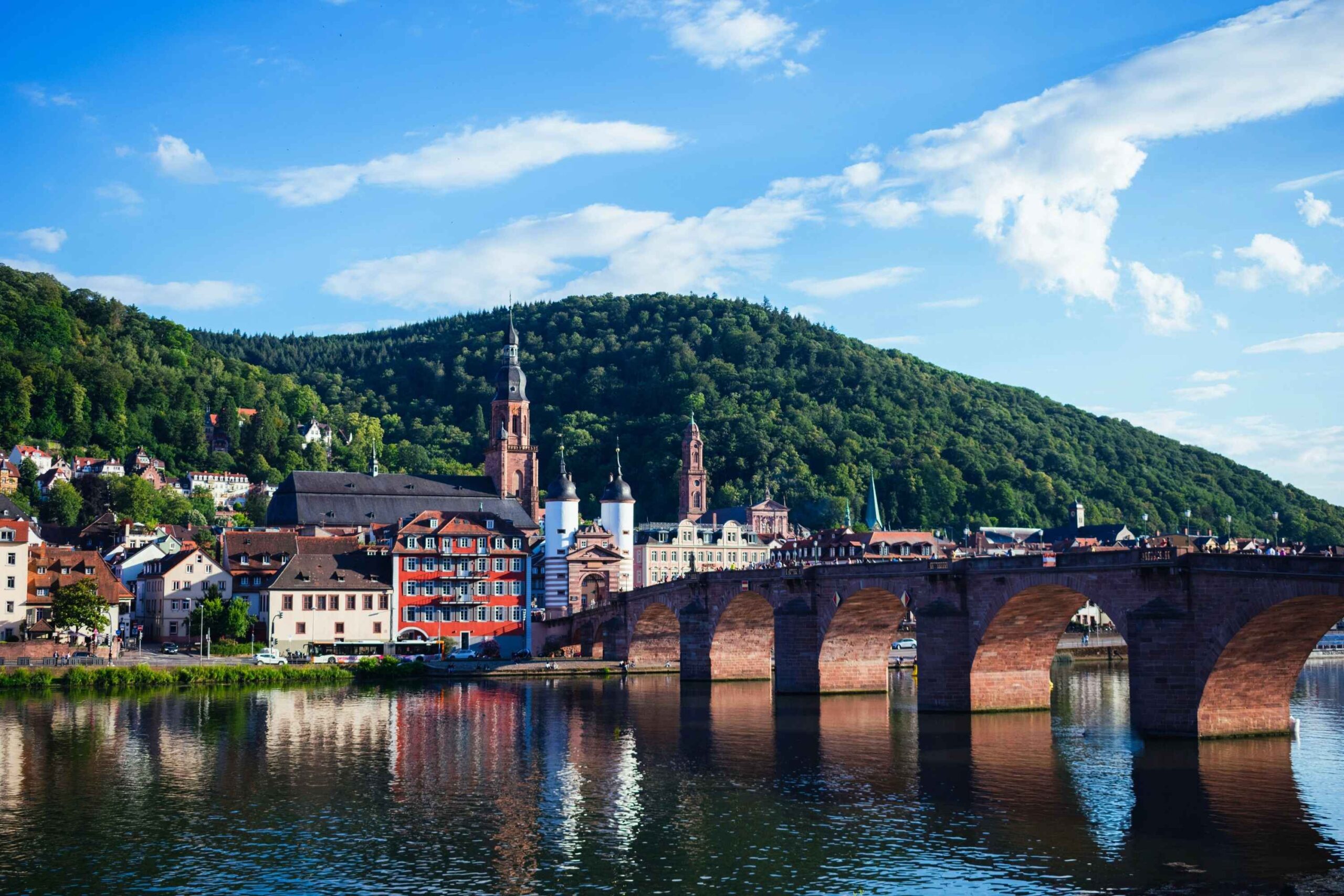 Heidelberg Historische Alte Brücke in Heidelberg über den Neckar mit Blick auf Altstadt und Kirchtürme, in malerischer Flusslandschaft.