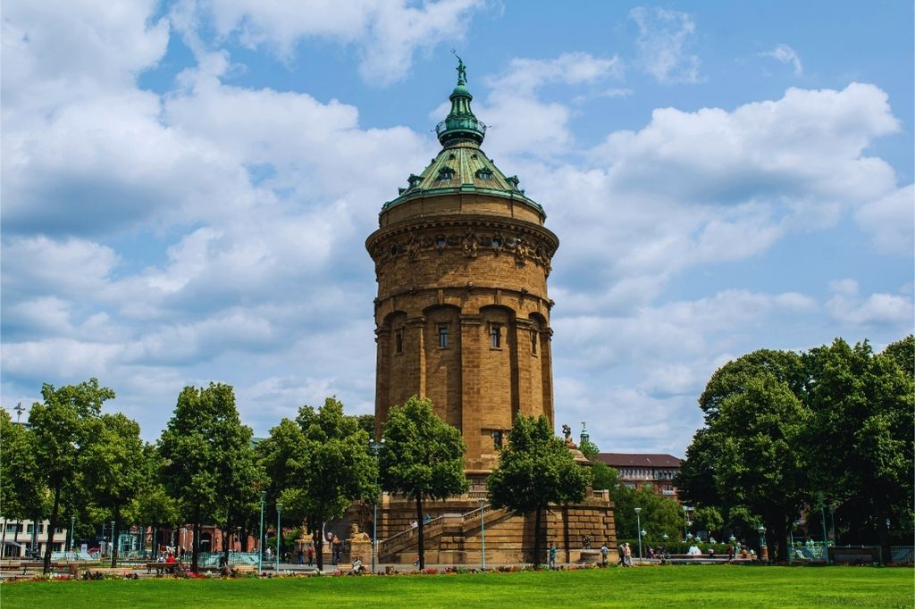 Historischer Wasserturm in Mannheim, umgeben von Bäumen und Grünflächen – architektonisches Wahrzeichen mit kuppelartigem Dach und klassizistischen Details.