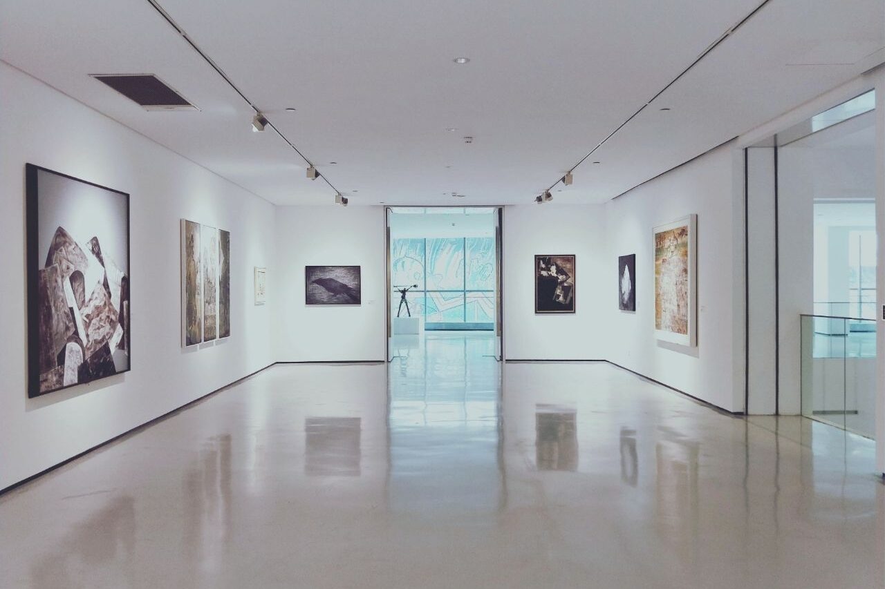 Galerieraum mit Kunstwerken an weißen Wänden, repräsentativ für kulturelle oder freizeitbezogene Einrichtungen – typische Umgebung im Kontext Gebäudereinigung Freizeit und Kultur Heidelberg.