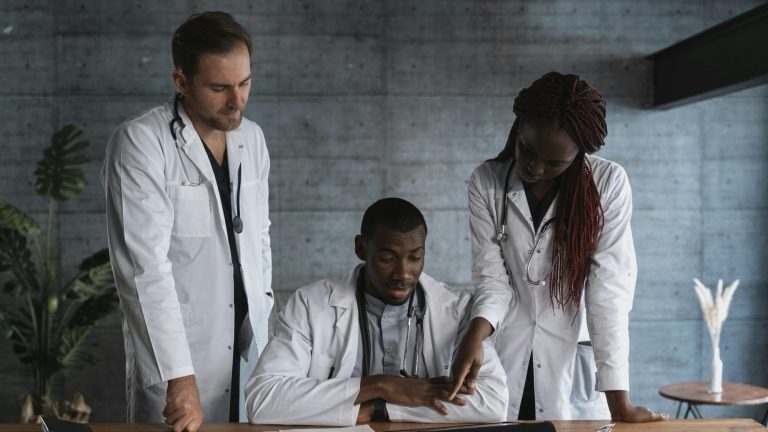 Medizinisches Fachpersonal mit Unterlagen, Tablet und Smartpone, bespricht  im kollegialen Austausch Personalvermittlung für Gesundheitsberufe mit Fokus auf Qualität und Teamfähigkeit