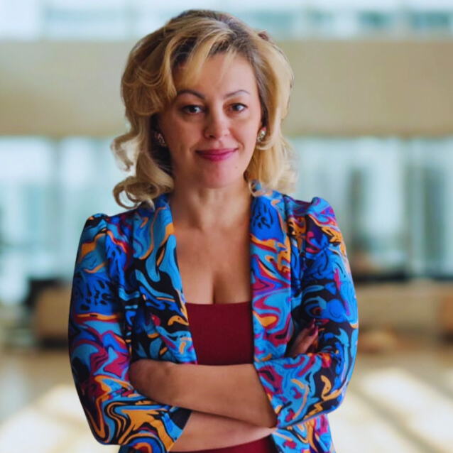 Ivana Cvetković Gicev, Geschäftsführerin der Lacidem GmbH, in professioneller Pose mit farbenfroher Jacke – Symbol für Führung, Persönlichkeit und moderne Markenidentität.