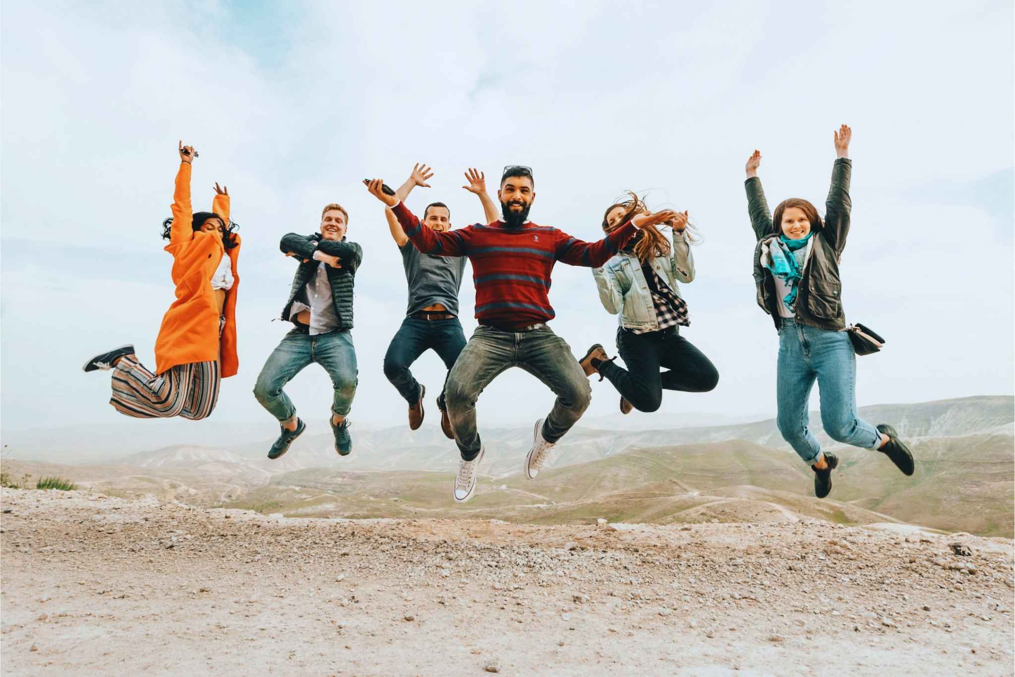 Personalvermittlung Karriere „Gruppe von Menschen, die gemeinsam im Freien springen und Freude ausdrücken – Symbol für Teamgeist und positive berufliche Perspektiven.